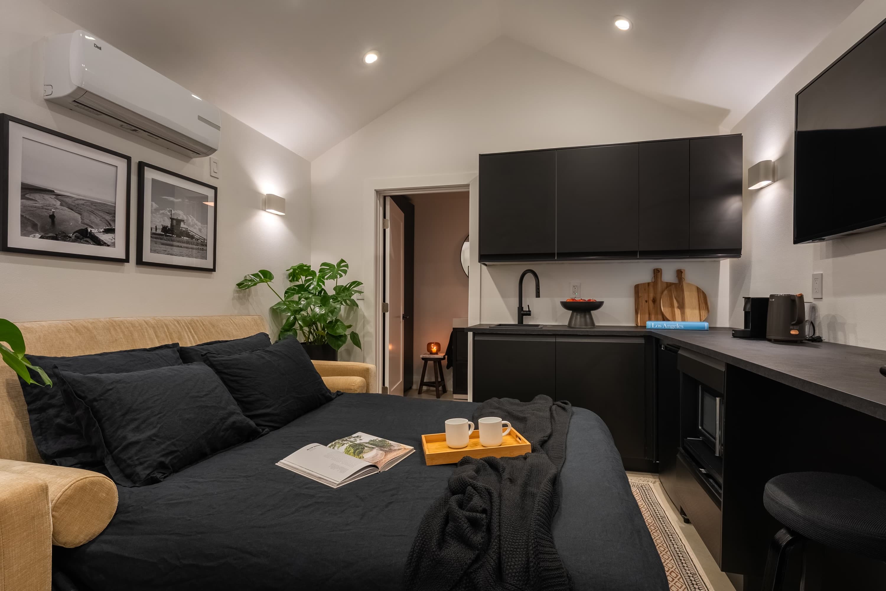 The bed sits under the vault, with the kitchenette on the far wall.